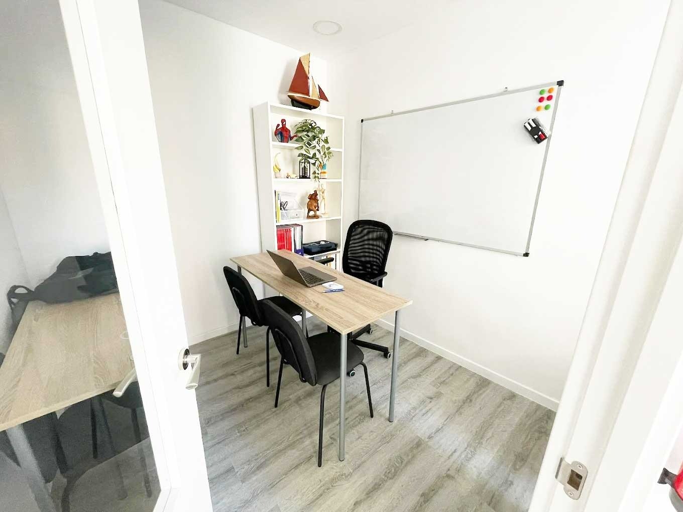 Aula pequeña con mesa y pizarra